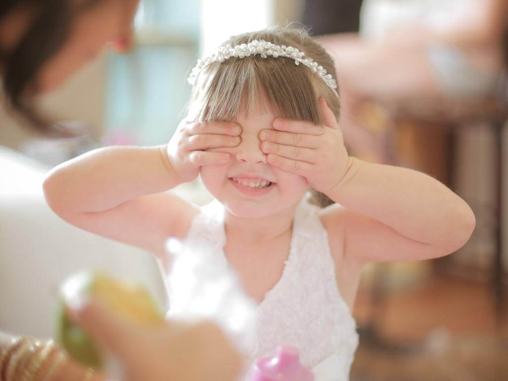 Lustige Hochzeitsfoto Idee mit Kindern: Kleines Mädchen hält sich ganz fest die Augen zu
