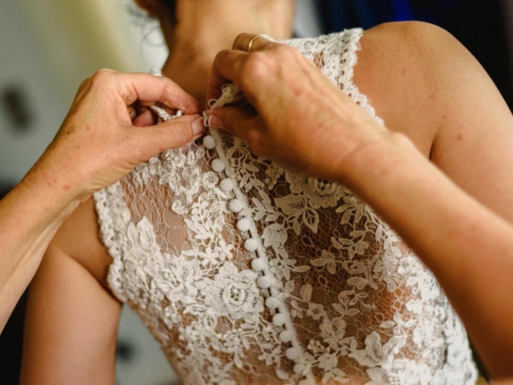 Checkliste für Hochzeitsfotos - Brautkleid schließen