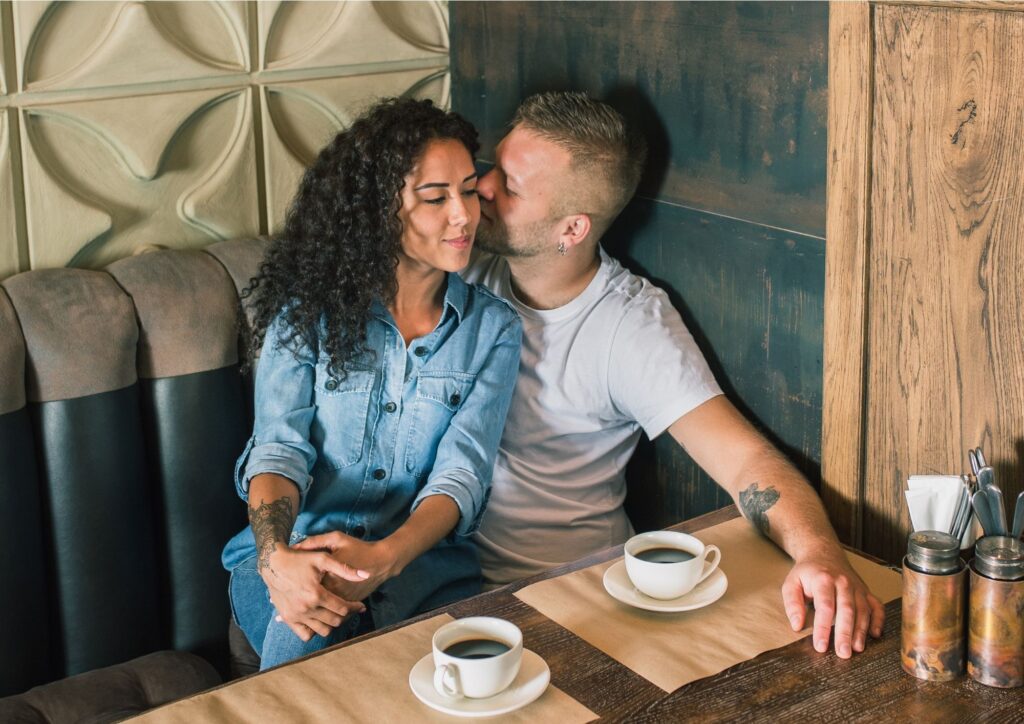 Verlobtes Paar sitzt gemeinsam in einem Café und trinkt Kaffee