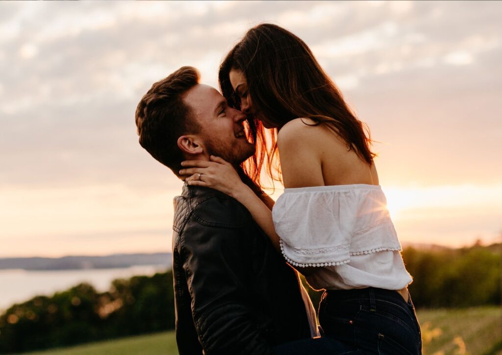 Verlobtes Paar küsst sich im warmen Licht der Abendsonne