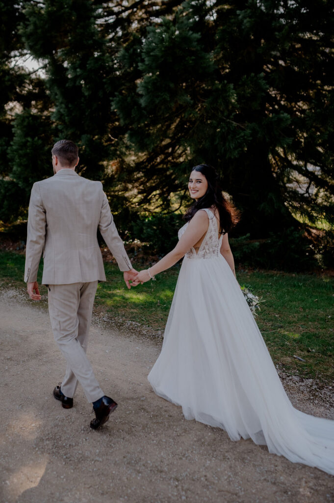 Brautpaar geht Hand in Hand – eine der einfachsten Posen für natürliche Hochzeitsfotos