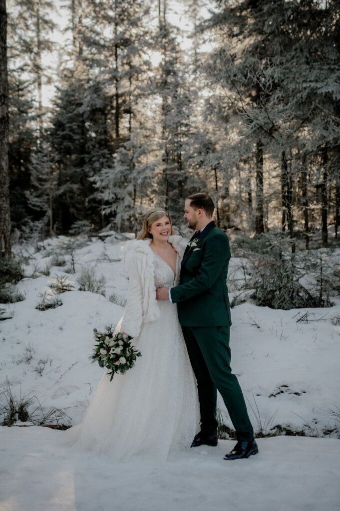 Hochzeitsmotto Winter, Brautpaar im verschneiten Wald